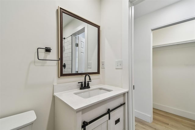 3535 16th St N, Saint Petersburg, FL 33704 - bathroom featuring toilet, wood finished floors, vanity, and baseboards
