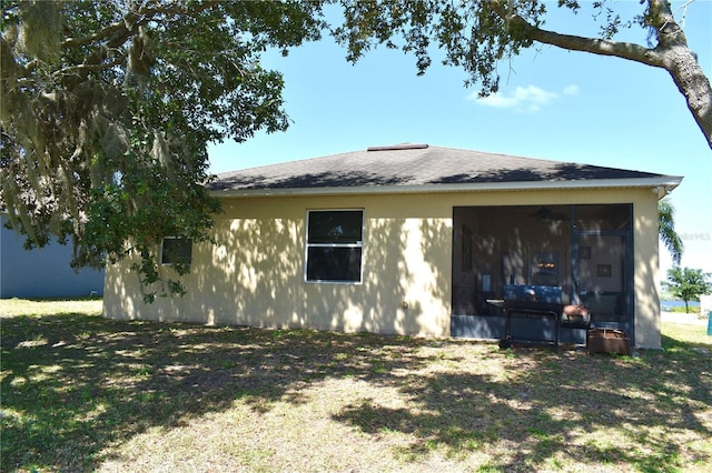 view of home's exterior with a sunroom and stucco siding
