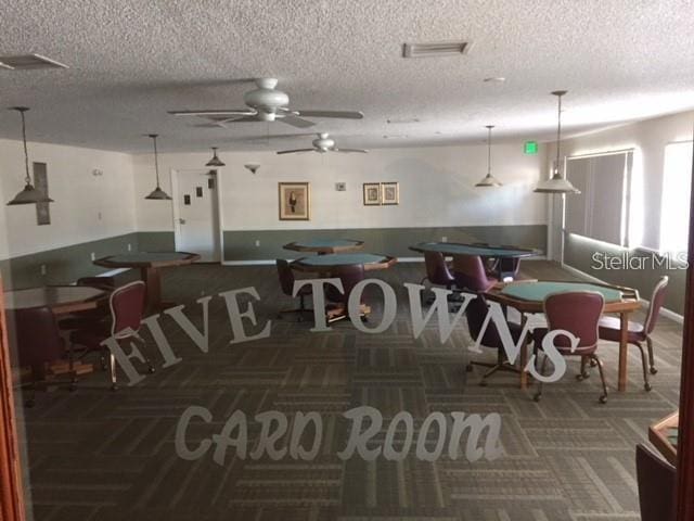 dining room with carpet flooring, a textured ceiling, and visible vents