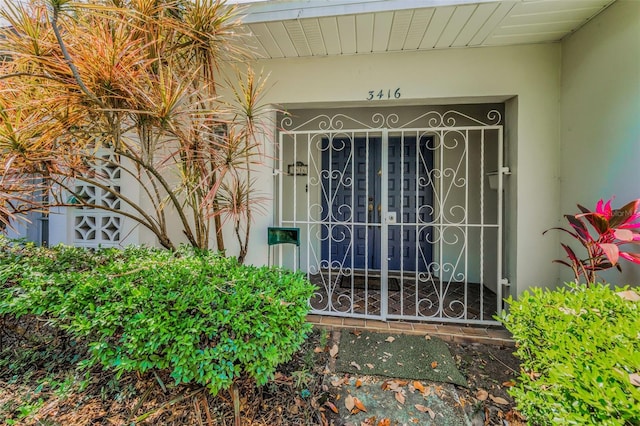property entrance featuring stucco siding and a gate