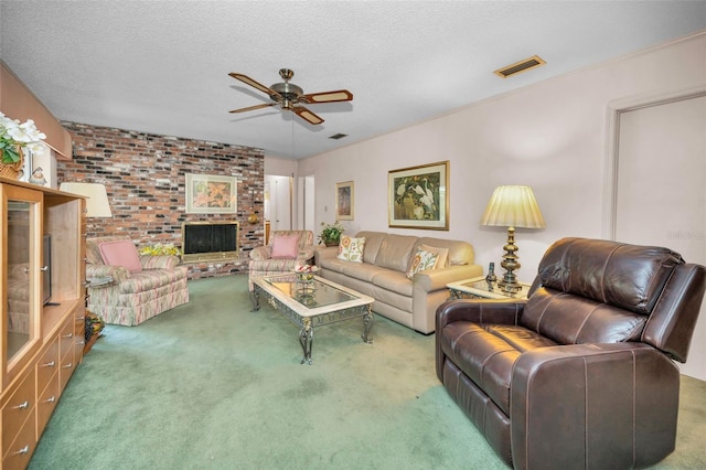 carpeted living area featuring a ceiling fan, brick wall, a fireplace, and a textured ceiling
