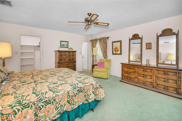 bedroom featuring carpet floors, a textured ceiling, and a ceiling fan
