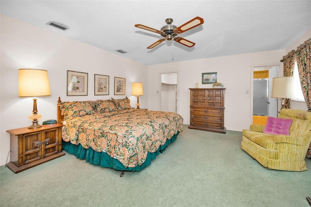 bedroom with carpet floors, a walk in closet, a textured ceiling, a ceiling fan, and a closet