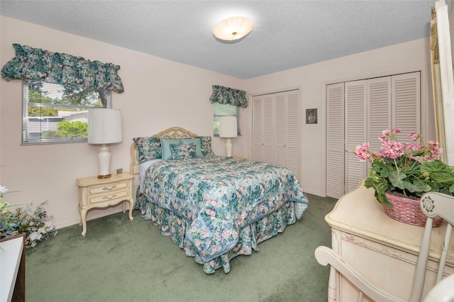 carpeted bedroom featuring multiple closets and a textured ceiling