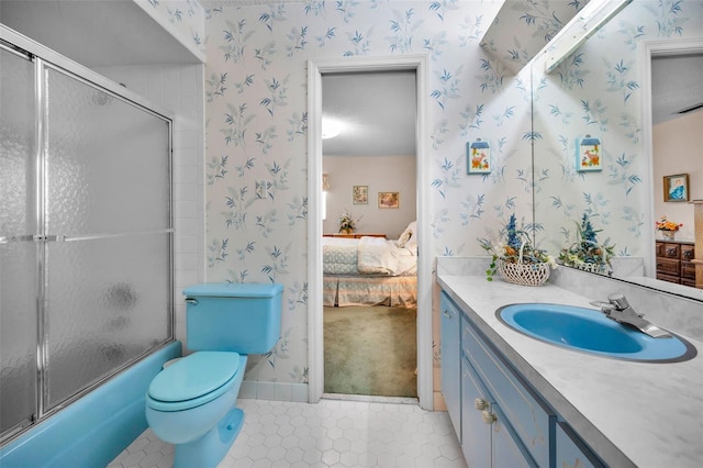ensuite bathroom with wallpapered walls, tile patterned floors, vanity, toilet, and enclosed tub / shower combo