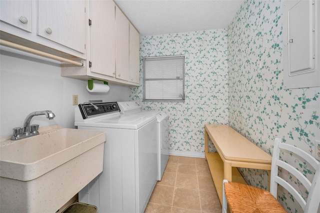 washroom featuring wallpapered walls, cabinet space, electric panel, washer and dryer, and baseboards