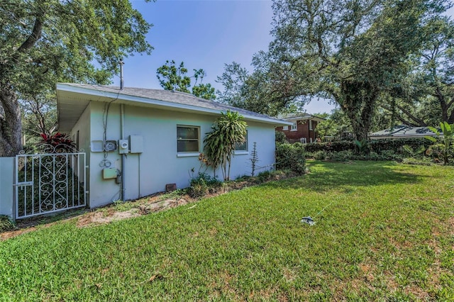 view of side of property featuring stucco siding and a gate