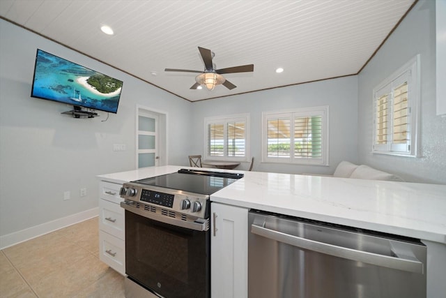 kitchen featuring light stone countertops, stainless steel appliances, and white cabinets