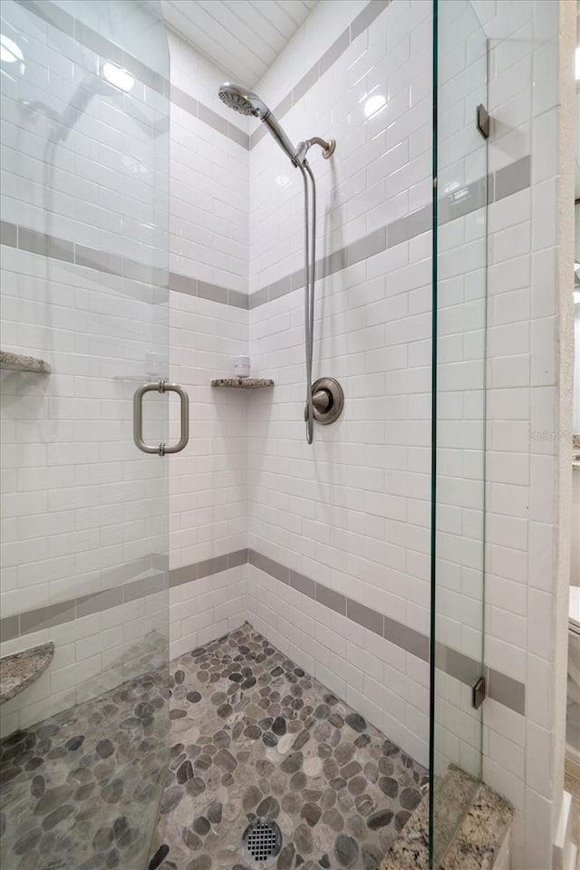 full bathroom featuring a stall shower and stone finish flooring