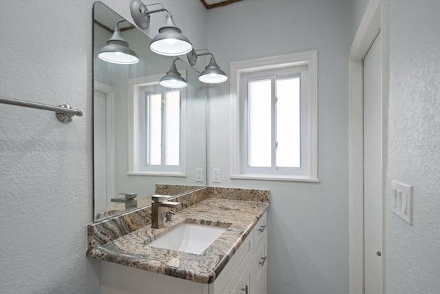 bathroom with vanity and a textured wall