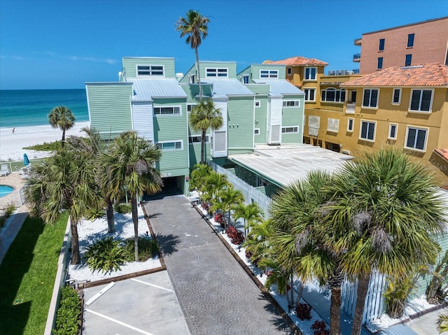 view of home's community featuring a water view and a beach view