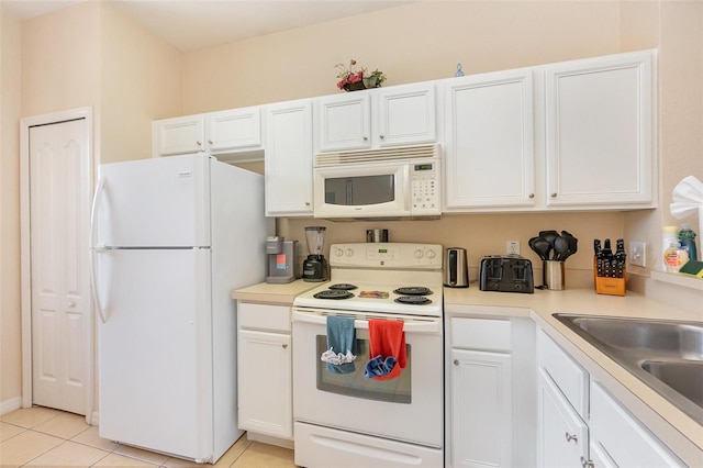 kitchen with white appliances, white cabinets, and light countertops