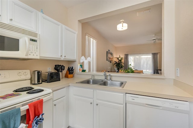 kitchen with white appliances, a sink, light countertops, and white cabinetry