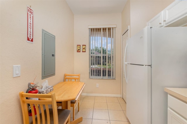 dining area featuring electric panel, light tile patterned flooring, and baseboards