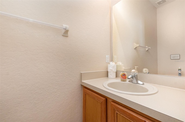 bathroom with vanity and a textured wall