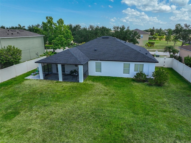 rear view of house featuring a patio, a sunroom, a shingled roof, a fenced backyard, and a yard
