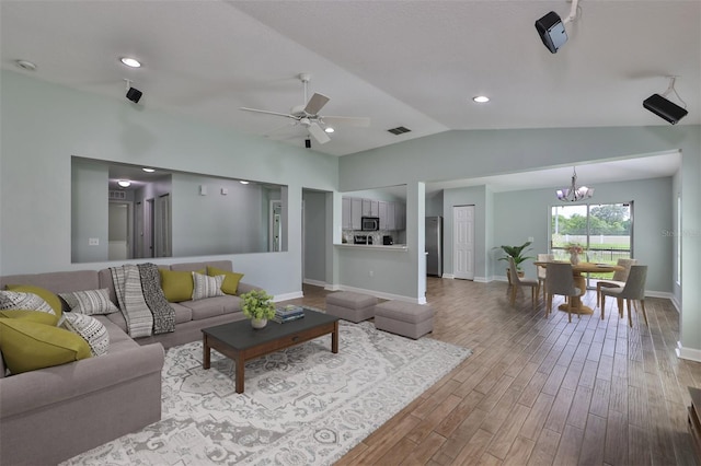 living room with wood finished floors, ceiling fan with notable chandelier, visible vents, baseboards, and lofted ceiling