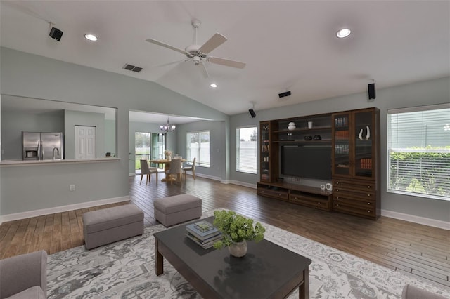 living room with lofted ceiling, wood-type flooring, and visible vents