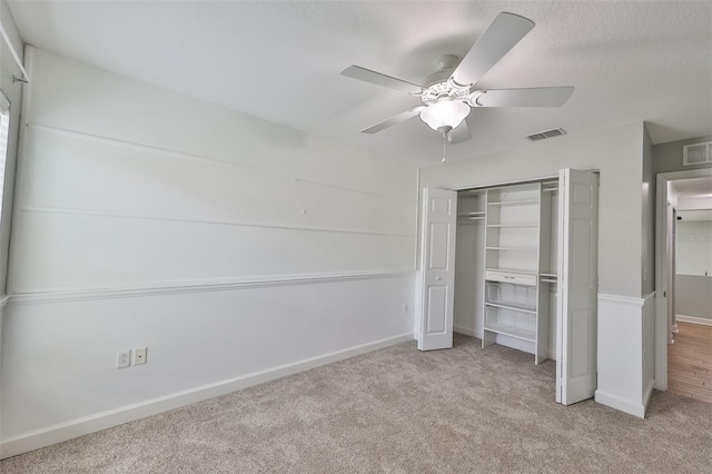 unfurnished bedroom featuring ceiling fan, carpet floors, a closet, and visible vents