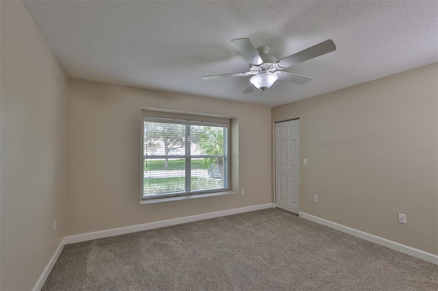 unfurnished room with carpet, a textured ceiling, baseboards, and ceiling fan