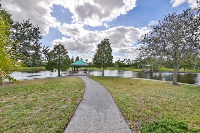 view of property's community with a gazebo, a water view, and a lawn