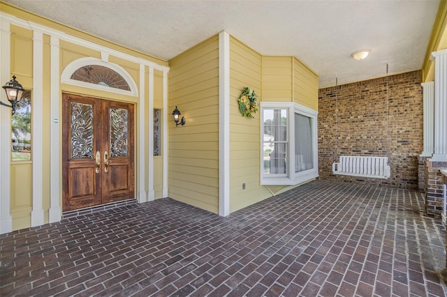 2769 St Andrews Blvd, Tarpon Springs, FL 34688 - property entrance with radiator, covered porch, and brick siding
