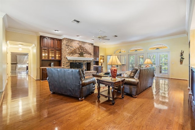 2769 St Andrews Blvd, Tarpon Springs, FL 34688 - living room with a fireplace, a ceiling fan, light wood-style flooring, crown molding, and baseboards
