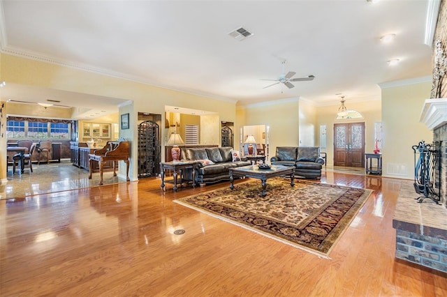2769 St Andrews Blvd, Tarpon Springs, FL 34688 - living area with healthy amount of natural light, wood finished floors, ceiling fan, crown molding, and a brick fireplace
