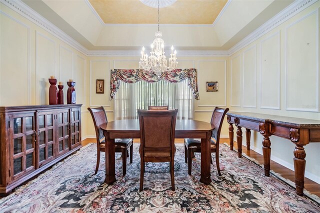 2769 St Andrews Blvd, Tarpon Springs, FL 34688 - dining room with a decorative wall, a chandelier, wood finished floors, and a raised ceiling