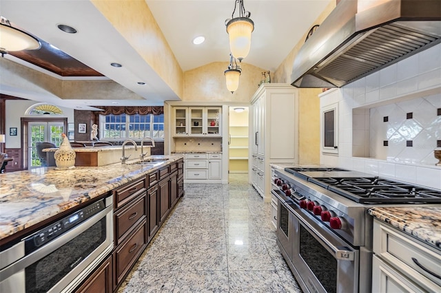 2769 St Andrews Blvd, Tarpon Springs, FL 34688 - kitchen with range with two ovens, wall chimney range hood, a sink, backsplash, and recessed lighting