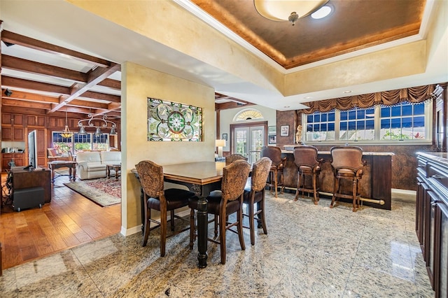 2769 St Andrews Blvd, Tarpon Springs, FL 34688 - dining area featuring a dry bar, a raised ceiling, baseboards, beam ceiling, and french doors