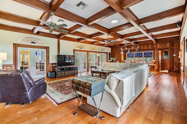 2769 St Andrews Blvd, Tarpon Springs, FL 34688 - living room featuring ceiling fan, french doors, beam ceiling, coffered ceiling, and light wood-style flooring