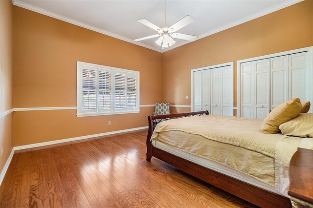 2769 St Andrews Blvd, Tarpon Springs, FL 34688 - bedroom with two closets, baseboards, wood finished floors, crown molding, and a ceiling fan