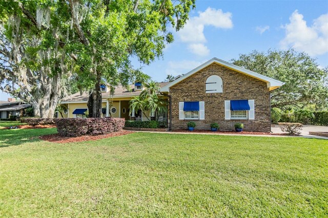 2769 St Andrews Blvd, Tarpon Springs, FL 34688 - view of front facade featuring a front lawn and brick siding