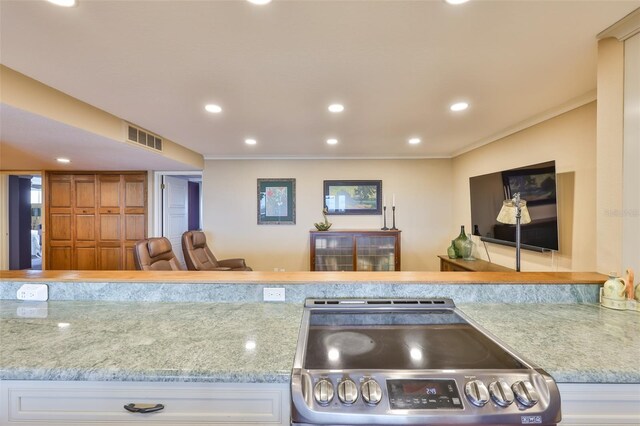5701 Mariner St Unit 701, Tampa, FL 33609 - kitchen featuring electric stove, crown molding, recessed lighting, light stone countertops, and white cabinetry