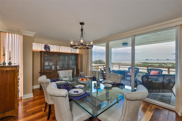 5701 Mariner St Unit 701, Tampa, FL 33609 - dining space featuring wood finished floors, a chandelier, ornamental molding, and baseboards