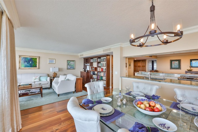 5701 Mariner St Unit 701, Tampa, FL 33609 - dining room with a chandelier, wood finished floors, ornamental molding, and a textured ceiling