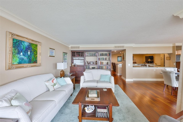 5701 Mariner St Unit 701, Tampa, FL 33609 - living room featuring crown molding, wood finished floors, a textured ceiling, and baseboards