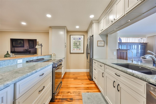 5701 Mariner St Unit 701, Tampa, FL 33609 - kitchen with stainless steel appliances, a sink, baseboards, light wood-type flooring, and light stone countertops