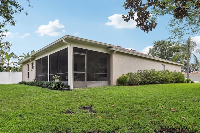 13813 Sigler St, Riverview, FL 33579 - rear view of property with a yard, stucco siding, a sunroom, and fence