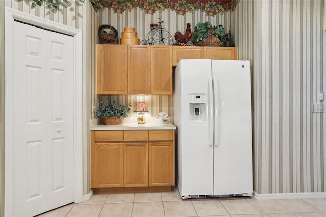 13813 Sigler St, Riverview, FL 33579 - kitchen with white fridge with ice dispenser, wallpapered walls, baseboards, light tile patterned floors, and light countertops