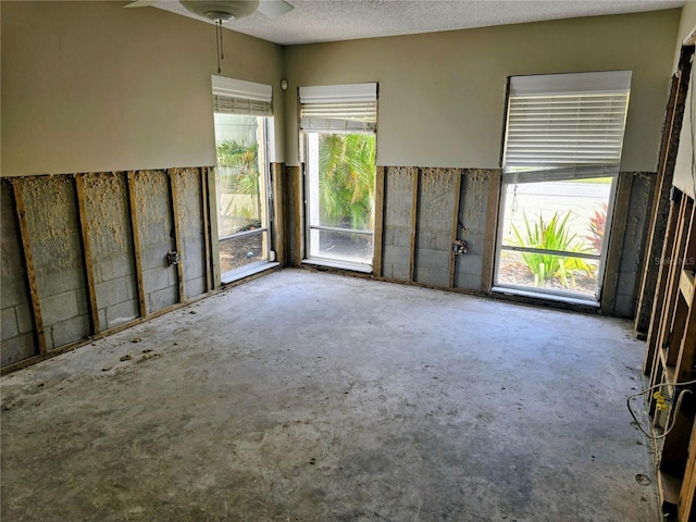 unfurnished room featuring concrete floors and ceiling fan