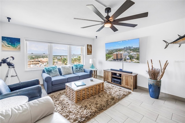 living room with ceiling fan and baseboards