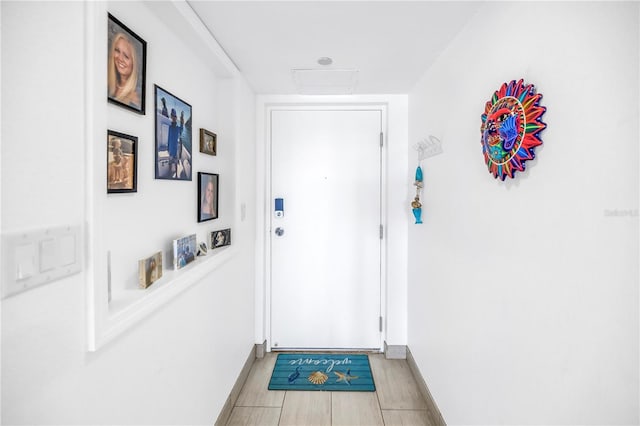 doorway to outside with light wood finished floors and baseboards