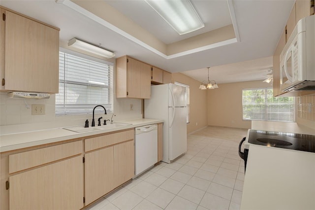 kitchen with white appliances, a sink, light brown cabinetry, and decorative backsplash