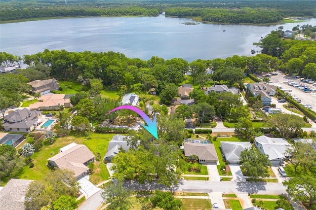 aerial view of residential area featuring a large body of water and a forest