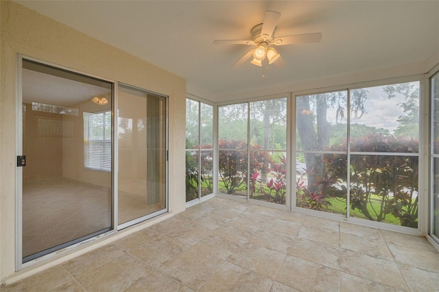 unfurnished sunroom featuring ceiling fan
