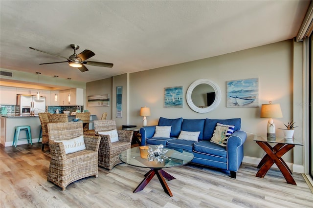 400 Island Way Unit 1709, Clearwater Beach, FL 33767 - living room with light wood finished floors, a ceiling fan, and baseboards