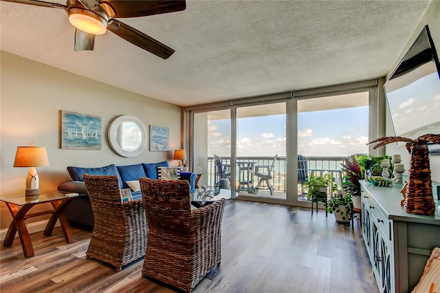 400 Island Way Unit 1709, Clearwater Beach, FL 33767 - living room featuring a wall of windows, wood finished floors, a textured ceiling, and a ceiling fan