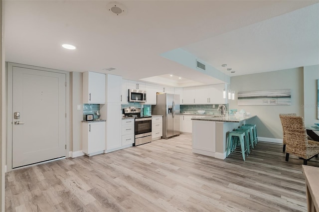 400 Island Way Unit 1709, Clearwater Beach, FL 33767 - kitchen with appliances with stainless steel finishes, light wood-style flooring, a peninsula, a breakfast bar, and recessed lighting
